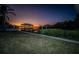Backyard featuring a pathway leading to a waterfront dock with boat lifts and a beautiful sunset at 1616 Sea Breeze Dr, Tarpon Springs, FL 34689