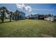 Expansive backyard featuring lush lawn and two waterfront homes under a bright sky at 1616 Sea Breeze Dr, Tarpon Springs, FL 34689