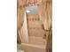 Tiled bathtub with tan tiles and matching diamond accents. A curtain is drawn to the side at 1616 Sea Breeze Dr, Tarpon Springs, FL 34689