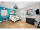 Stylish bedroom featuring cool-toned walls, plank wood flooring, decorative artwork, and a ceiling fan at 1616 Sea Breeze Dr, Tarpon Springs, FL 34689