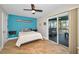 Bedroom with light tile floors and a sliding glass door to a screened in patio at 1616 Sea Breeze Dr, Tarpon Springs, FL 34689