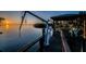 Picturesque waterfront dock featuring a covered gazebo, boat lift, and stunning sunset views at 1616 Sea Breeze Dr, Tarpon Springs, FL 34689