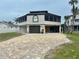 Contemporary two-story home featuring a modern roofline, attached garage, and well-manicured lawn at 1616 Sea Breeze Dr, Tarpon Springs, FL 34689