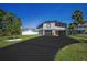 Two-story home with a large driveway, screened in porch and well-manicured lawn at 1616 Sea Breeze Dr, Tarpon Springs, FL 34689