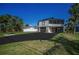 Well-kept, two-story home features an orange door and a large driveway with lush landscaping at 1616 Sea Breeze Dr, Tarpon Springs, FL 34689