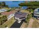 An exterior view of a unique home, including the driveway, garage, and view of the intercoastal waters behind the home at 1616 Sea Breeze Dr, Tarpon Springs, FL 34689