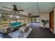Screened lanai featuring ceiling fans, stylish furnishings, and views of the surrounding landscape at 1616 Sea Breeze Dr, Tarpon Springs, FL 34689