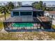 Aerial view of a screened-in pool area, a deck, and surrounding landscape of the home at 1616 Sea Breeze Dr, Tarpon Springs, FL 34689