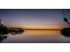 Scenic waterfront view at dusk, featuring calm waters, lush mangroves, and a colorful horizon at 1616 Sea Breeze Dr, Tarpon Springs, FL 34689