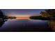 Gorgeous twilight waterfront view with calm water, and mangrove islands along the horizon at 1616 Sea Breeze Dr, Tarpon Springs, FL 34689