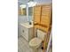 Well-lit bathroom featuring a modern vanity, with an over the toilet wooden storage cabinet at 20893 Haulover Cv # 8, Lutz, FL 33558