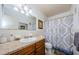 Bathroom with decorative shower curtain, vanity with granite countertop, and an framed mirror at 2261 Swedish Dr # 33&35, Clearwater, FL 33763