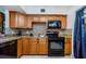 Traditional kitchen features wood cabinets, a mosaic tile backsplash, and black appliances at 2261 Swedish Dr # 33&35, Clearwater, FL 33763