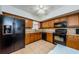 The kitchen showcases warm wood cabinets and modern black appliances, nice tile flooring at 2261 Swedish Dr # 33&35, Clearwater, FL 33763