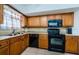 Classic kitchen with wood cabinetry, black appliances, and tile flooring at 2261 Swedish Dr # 33&35, Clearwater, FL 33763