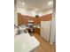 Bright kitchen showcases wood cabinets, an electric range, laminate floors and a white refrigerator at 2931 Walnut Grove Ct, Holiday, FL 34691