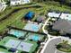 An aerial view displays multiple community amenities including pools, tennis courts, and play areas in a scenic setting at 3060 Mountain Spruce Ter, Wesley Chapel, FL 33543