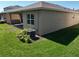 A home's exterior reveals a stucco wall, window, and air conditioning unit surrounded by grass and decorative plants at 3060 Mountain Spruce Ter, Wesley Chapel, FL 33543