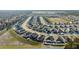 Aerial view of a residential community with modern homes, tree-lined streets, and a large open field at 3667 Autumn Amber Dr, Spring Hill, FL 34609