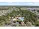 Aerial view of a community pool with a playground and splash pad surrounded by trees and homes at 3667 Autumn Amber Dr, Spring Hill, FL 34609