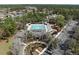 Aerial view of community pool with a playground and ample parking surrounded by trees at 3667 Autumn Amber Dr, Spring Hill, FL 34609