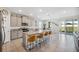 Bright, open kitchen with an island, barstool seating, stainless appliances, and sliding door access at 3667 Autumn Amber Dr, Spring Hill, FL 34609