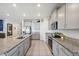 Modern kitchen showcasing granite counters, stainless appliances, ample cabinetry, and tile flooring at 3667 Autumn Amber Dr, Spring Hill, FL 34609