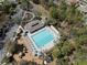 Aerial view of a community pool with lounge chairs, cabanas, playground, and ample parking at 3667 Autumn Amber Dr, Spring Hill, FL 34609
