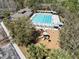 Aerial view of community pool with lounge chairs and umbrellas, and a playground with a slide at 3667 Autumn Amber Dr, Spring Hill, FL 34609