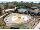 Aerial view of a splash pad surrounded by tables and lounge chairs near a community pool at 3667 Autumn Amber Dr, Spring Hill, FL 34609