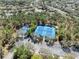 Aerial view of tennis courts and parking lot surrounded by trees and some homes at 3667 Autumn Amber Dr, Spring Hill, FL 34609