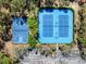 Aerial view of blue-colored community tennis and basketball courts, with lighting for nighttime play at 3667 Autumn Amber Dr, Spring Hill, FL 34609