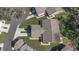 Aerial view of a home with a well-maintained lawn and a driveway, surrounded by other homes and mature trees at 3806 River Oaks Ct, New Port Richey, FL 34655