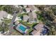Aerial view of a home with screened-in pool, a driveway, and a landscaped yard within a residential community at 3806 River Oaks Ct, New Port Richey, FL 34655