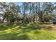 Expansive backyard with mature trees providing shade and privacy for outdoor enjoyment at 3806 River Oaks Ct, New Port Richey, FL 34655