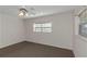 Carpeted bedroom with a ceiling fan and natural light from the window at 3806 River Oaks Ct, New Port Richey, FL 34655