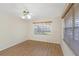 Bright bedroom with a ceiling fan, wood-look floors, and a window with blinds at 3806 River Oaks Ct, New Port Richey, FL 34655