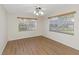 A bright bedroom with hardwood floors and multiple windows letting in natural light at 3806 River Oaks Ct, New Port Richey, FL 34655