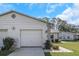 House exterior featuring a two-car garage, manicured lawn, and neat landscaping at 3806 River Oaks Ct, New Port Richey, FL 34655