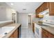 Functional kitchen with wood cabinetry, white appliances, and a tiled floor, ready for personalization at 3806 River Oaks Ct, New Port Richey, FL 34655