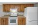 Close-up of the kitchen with white appliances and wooden cabinetry at 3806 River Oaks Ct, New Port Richey, FL 34655