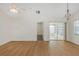 Bright living room with wood floors, ceiling fan, and sliding glass doors to the sunroom at 3806 River Oaks Ct, New Port Richey, FL 34655