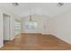 Open living room with wood-look floors, with many windows at 3806 River Oaks Ct, New Port Richey, FL 34655