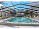 Large screened-in pool area with ample seating and a sparkling pool for outdoor relaxation and entertainment at 3806 River Oaks Ct, New Port Richey, FL 34655