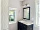 Bathroom with dark vanity, white countertops, and square mirror at 4009 N Seminole Ave, Tampa, FL 33603