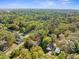 Aerial view of a home surrounded by lush green trees in a peaceful residential area at 406 Zoller St, Brooksville, FL 34601