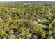 Aerial view of a house nestled among lush green trees in a quiet residential neighborhood at 406 Zoller St, Brooksville, FL 34601