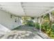 Covered carport area features a concrete floor and access to the backyard surrounded by trees at 406 Zoller St, Brooksville, FL 34601
