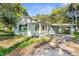 Charming single-story home featuring a covered carport and quaint front porch with red accents at 406 Zoller St, Brooksville, FL 34601