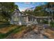 Single-story home with a covered carport and front porch surrounded by mature trees and greenery at 406 Zoller St, Brooksville, FL 34601